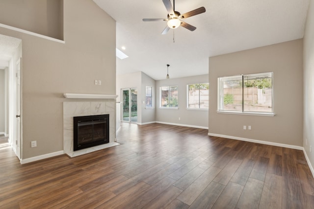 unfurnished living room featuring a premium fireplace, dark wood-type flooring, and plenty of natural light