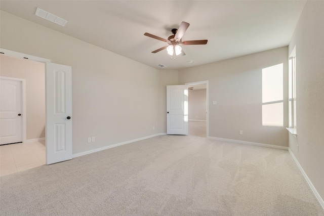 spare room featuring light carpet and ceiling fan