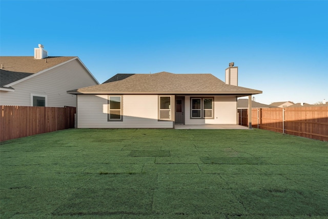 rear view of house with a yard and a patio