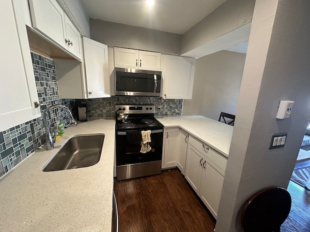 kitchen featuring dark wood-type flooring, stainless steel appliances, sink, white cabinetry, and tasteful backsplash