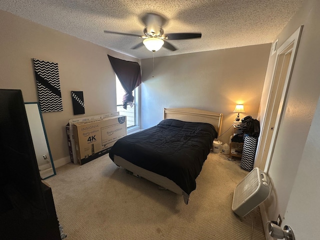 carpeted bedroom featuring a textured ceiling and ceiling fan