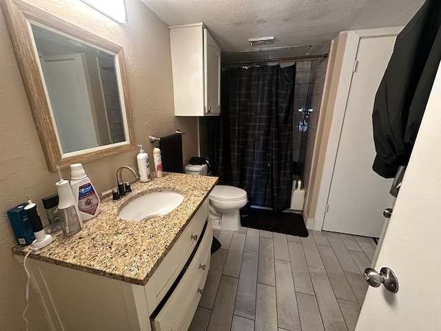 3022 Forest Ln Unit 221, Dallas, TX 75234 - full bathroom with vanity, a shower with curtain, wood tiled floor, a textured ceiling, and a textured wall