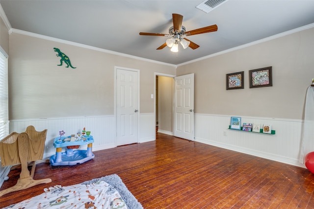 recreation room featuring crown molding, ceiling fan, and dark wood-type flooring