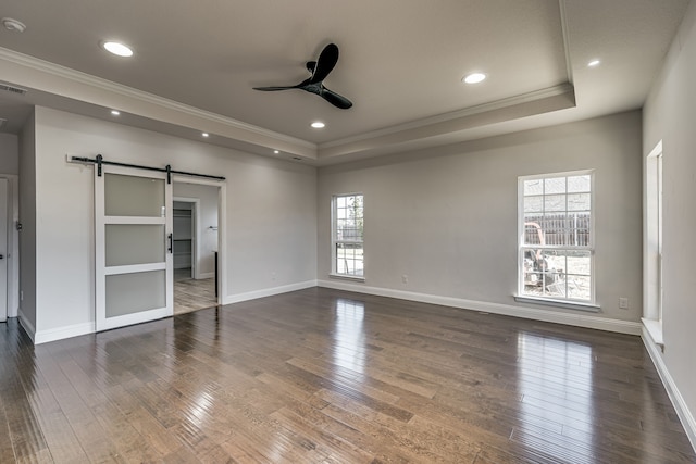 unfurnished bedroom featuring a barn door and dark wood-type flooring