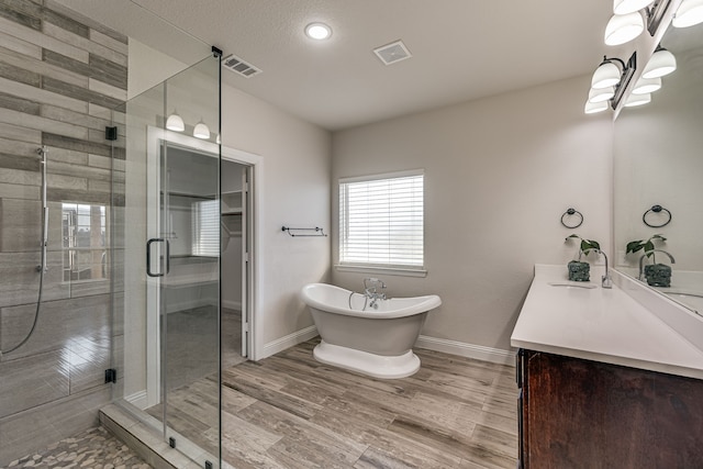 bathroom featuring hardwood / wood-style floors, vanity, and separate shower and tub