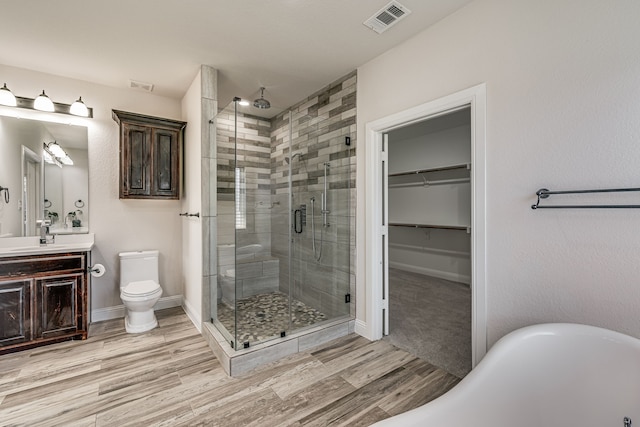 full bathroom featuring hardwood / wood-style floors, independent shower and bath, vanity, and toilet