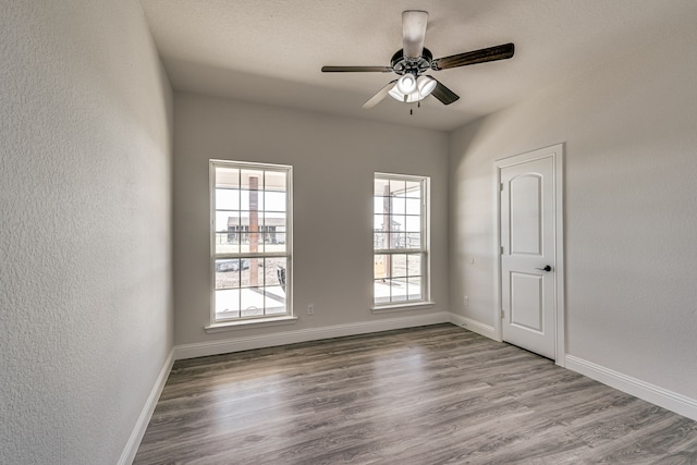 unfurnished room with ceiling fan and hardwood / wood-style flooring