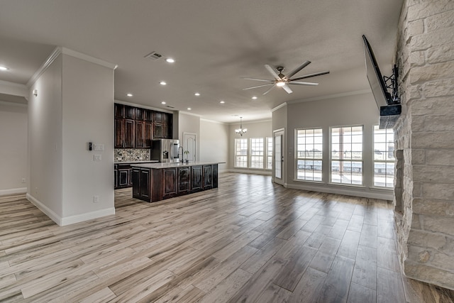 kitchen with ceiling fan with notable chandelier, light hardwood / wood-style flooring, a center island with sink, ornamental molding, and stainless steel fridge with ice dispenser