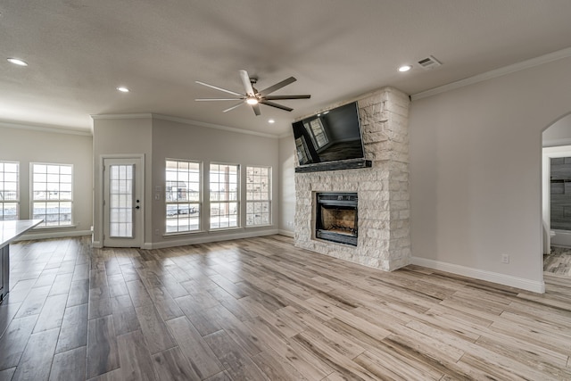 unfurnished living room featuring a fireplace, crown molding, and light hardwood / wood-style floors