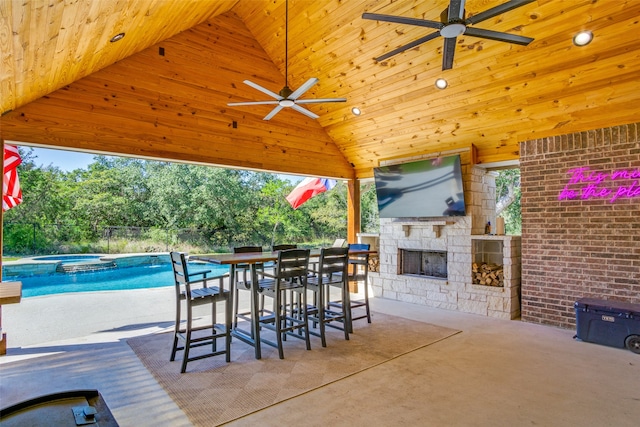 view of patio / terrace with ceiling fan and an outdoor stone fireplace