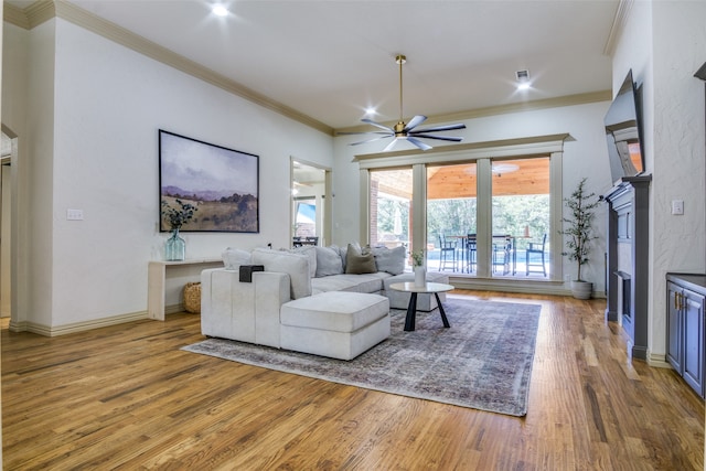 living room featuring ceiling fan, hardwood / wood-style floors, and crown molding