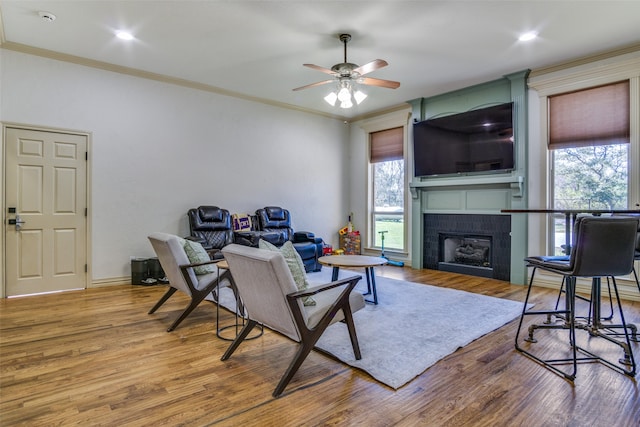 living room featuring a fireplace, light wood-type flooring, and ornamental molding