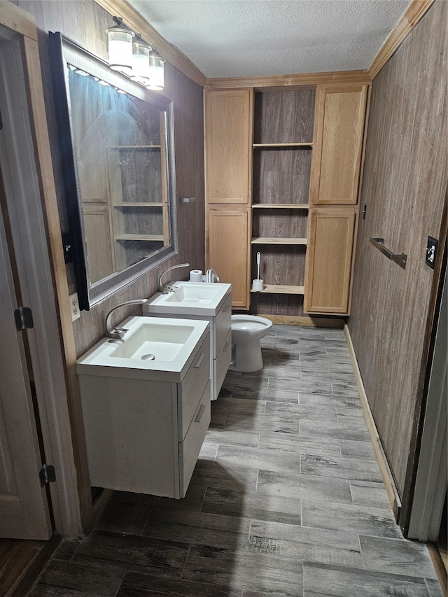 bathroom with a textured ceiling, hardwood / wood-style flooring, a shower, vanity, and toilet