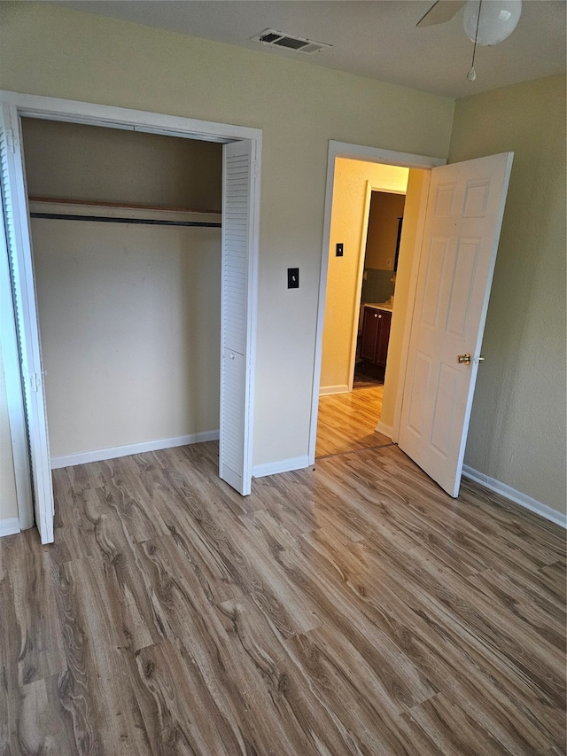 unfurnished bedroom featuring ceiling fan, a closet, and light hardwood / wood-style floors