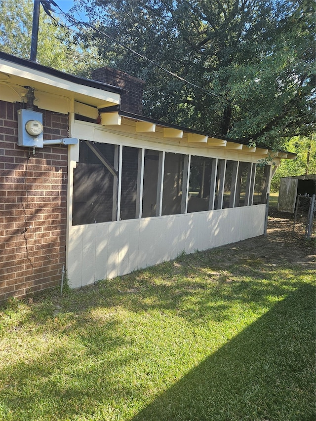 view of property exterior with a lawn and a sunroom