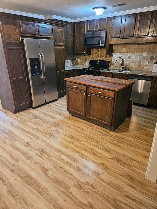 kitchen featuring dark brown cabinets, stainless steel appliances, light hardwood / wood-style floors, and sink