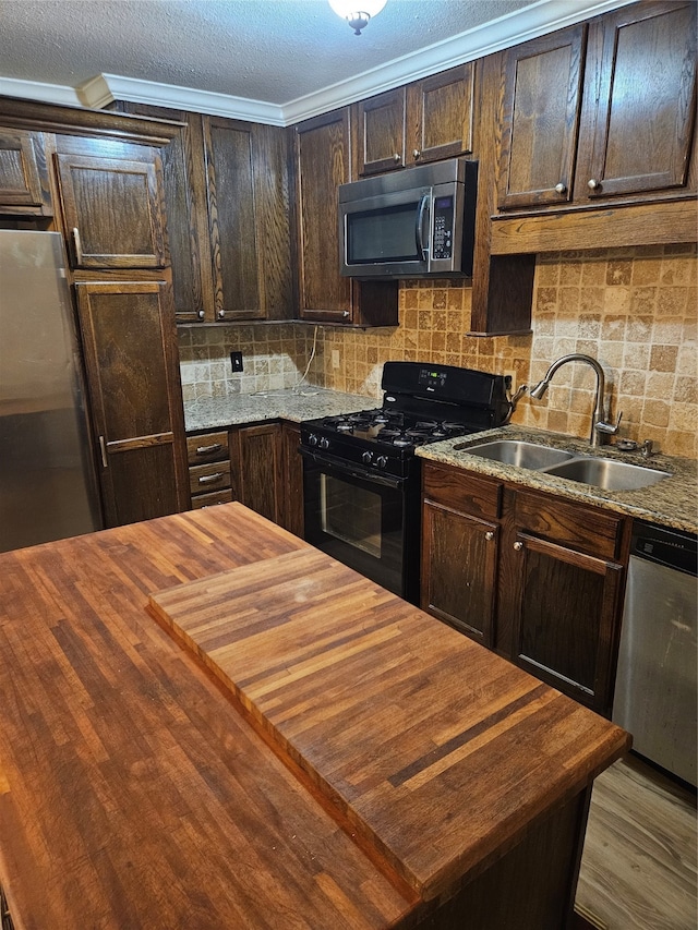 kitchen featuring dark brown cabinets, backsplash, sink, and stainless steel appliances