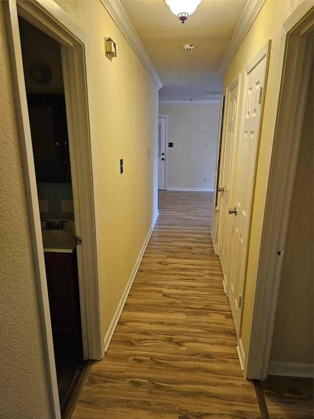 hall with hardwood / wood-style flooring and crown molding