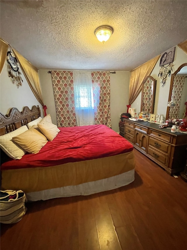 bedroom featuring a textured ceiling and dark hardwood / wood-style floors