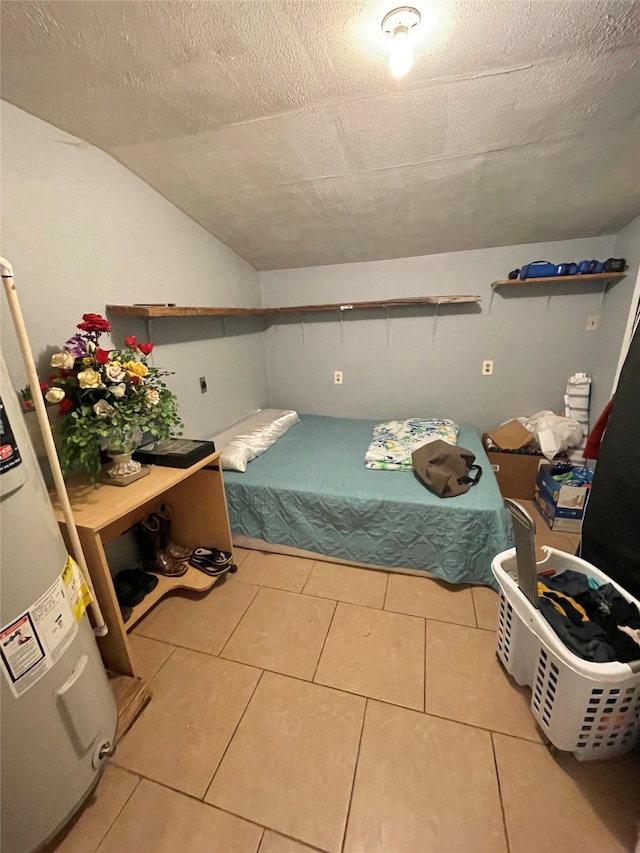 bedroom featuring tile patterned floors, water heater, vaulted ceiling, and a textured ceiling