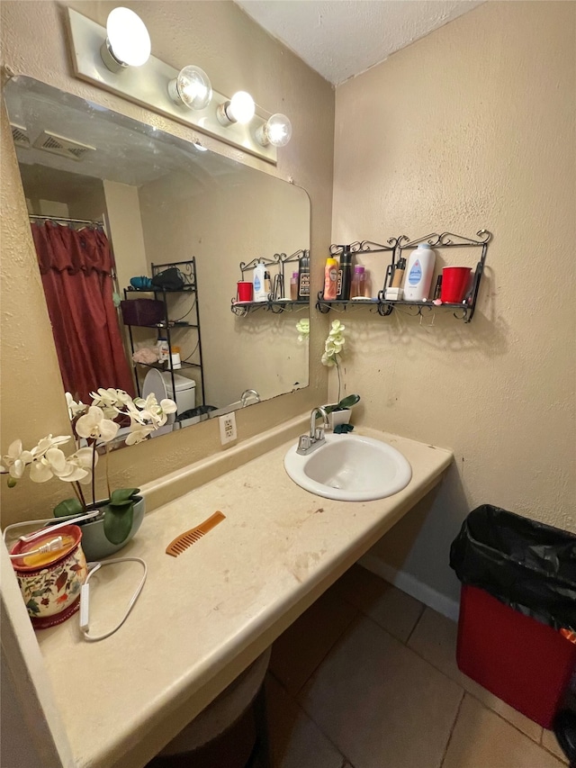 bathroom featuring tile patterned flooring, vanity, and a textured ceiling