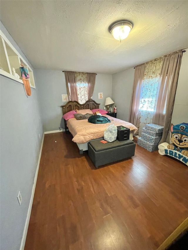 bedroom with dark wood-type flooring, multiple windows, and a textured ceiling