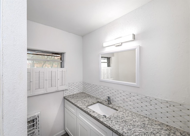 bathroom with vanity, heating unit, and plenty of natural light