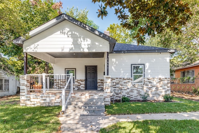 view of front of house with a porch and a front lawn