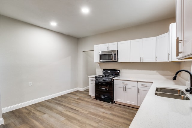 kitchen featuring white cabinetry, sink, light hardwood / wood-style flooring, and black range with gas stovetop