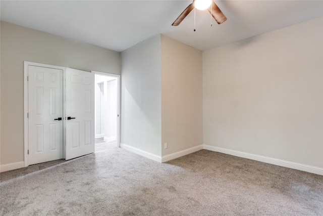 carpeted spare room featuring ceiling fan