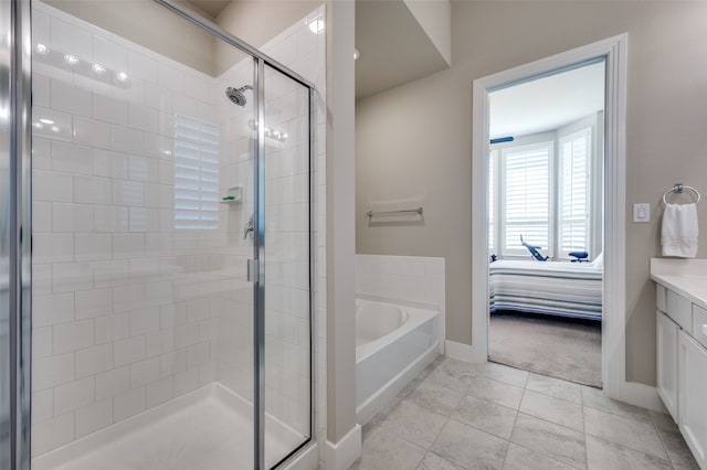 bathroom with tile patterned flooring, vanity, and independent shower and bath