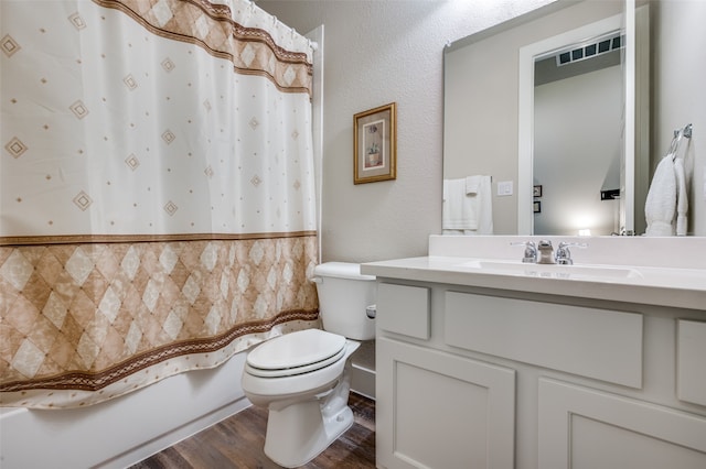 full bathroom featuring hardwood / wood-style flooring, vanity, toilet, and shower / tub combo with curtain