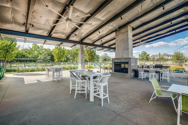 view of patio with a multi sided fireplace and ceiling fan