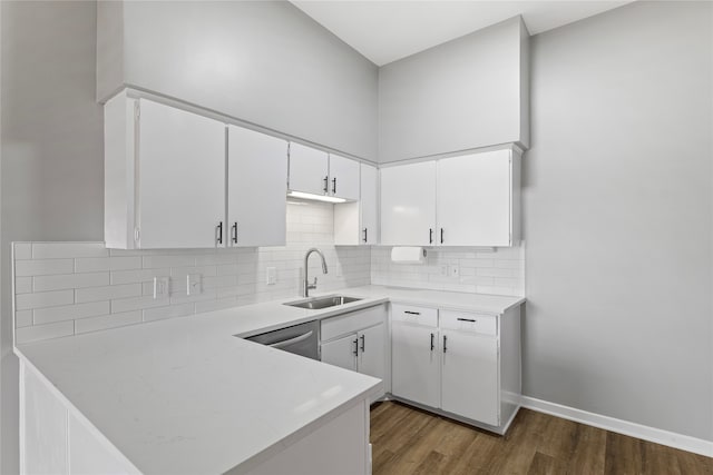 kitchen featuring sink, stainless steel dishwasher, backsplash, white cabinetry, and dark hardwood / wood-style flooring