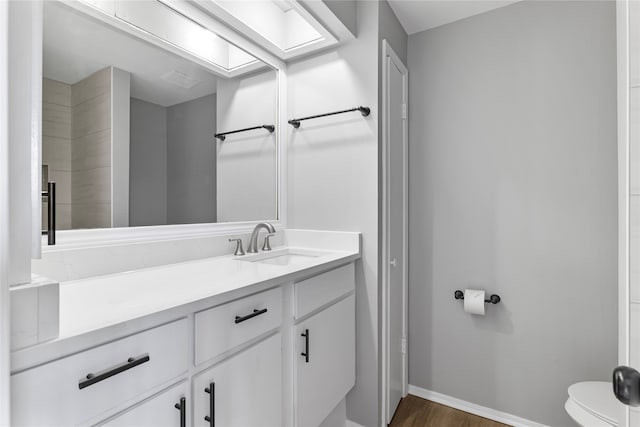 bathroom featuring hardwood / wood-style floors, vanity, and toilet