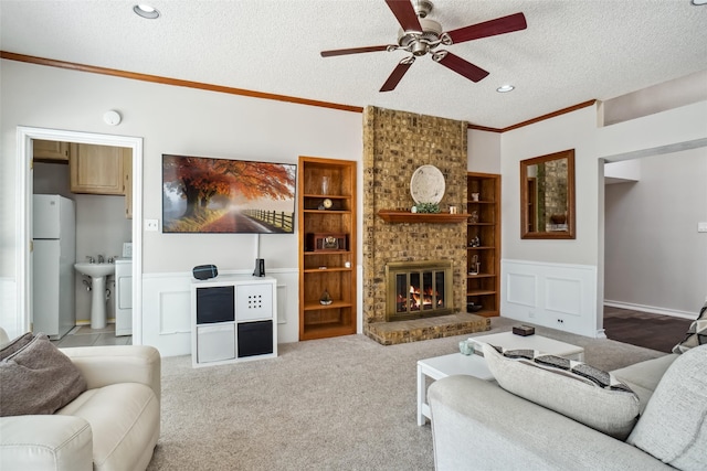 carpeted living room featuring washer / dryer, crown molding, a brick fireplace, a textured ceiling, and ceiling fan