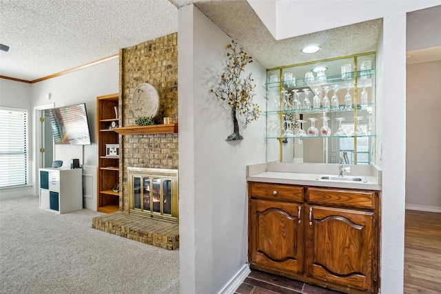 bar with dark wood-type flooring, crown molding, a textured ceiling, and sink