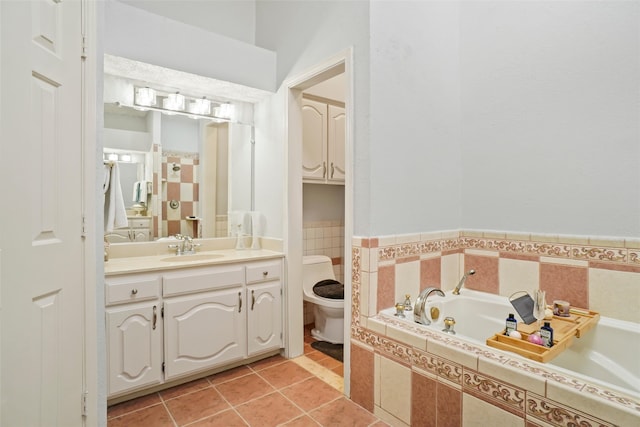 bathroom featuring vanity, tiled tub, toilet, and tile patterned flooring