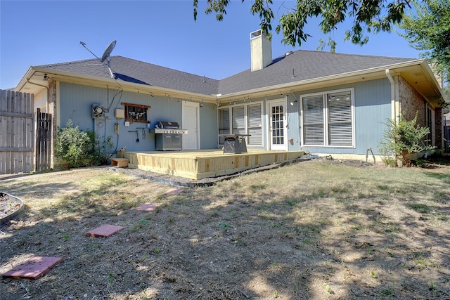 rear view of property with a deck and a lawn