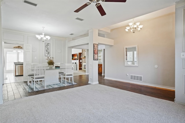 unfurnished dining area featuring dark wood-type flooring, a wealth of natural light, and ceiling fan with notable chandelier