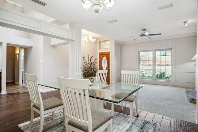 dining space with hardwood / wood-style floors and ceiling fan with notable chandelier