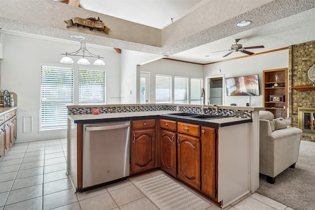 kitchen with a textured ceiling, stainless steel dishwasher, sink, and a wealth of natural light