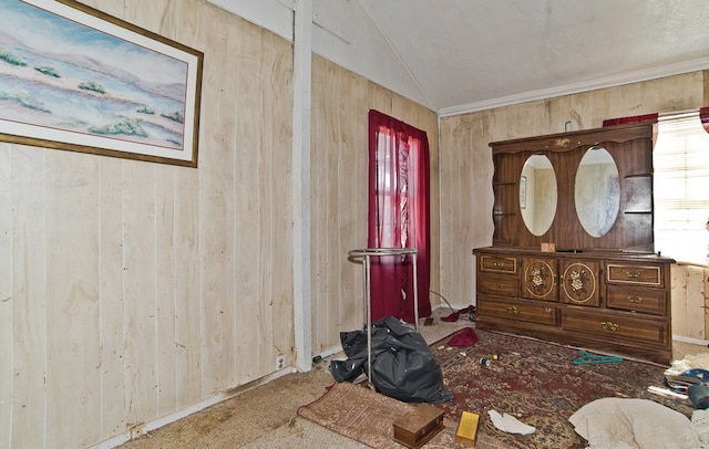 bedroom featuring vaulted ceiling and wood walls