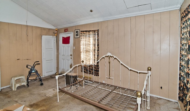 bedroom with wooden walls, vaulted ceiling, and carpet floors