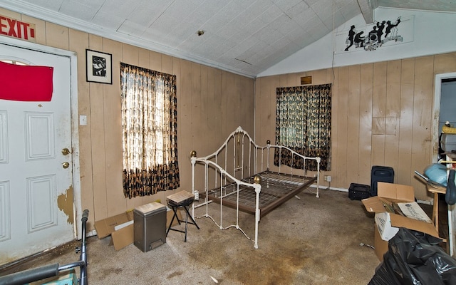 interior space featuring lofted ceiling with beams, wood walls, and carpet