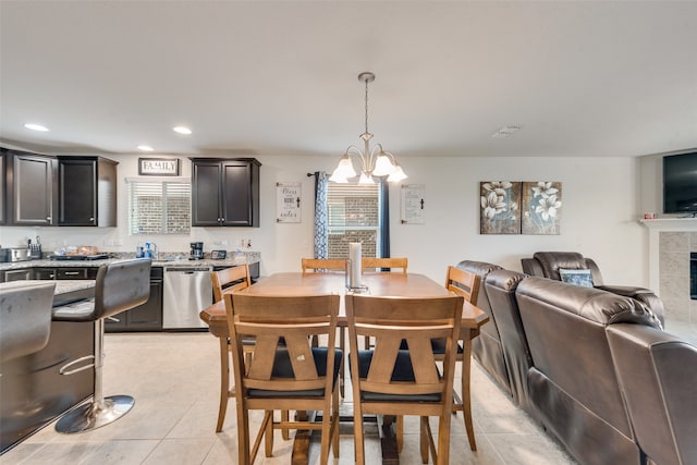 tiled dining area featuring a tile fireplace and an inviting chandelier