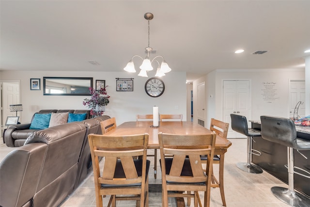 dining room featuring an inviting chandelier, crown molding, and light tile patterned flooring