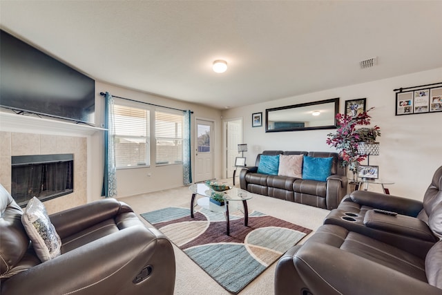 living room featuring carpet and a tiled fireplace