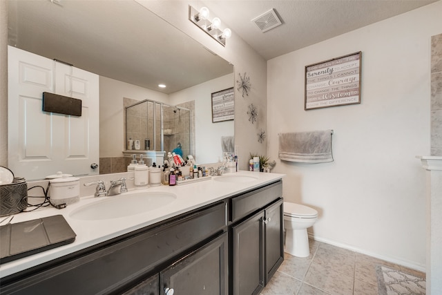 bathroom featuring a textured ceiling, a shower with door, tile patterned floors, vanity, and toilet