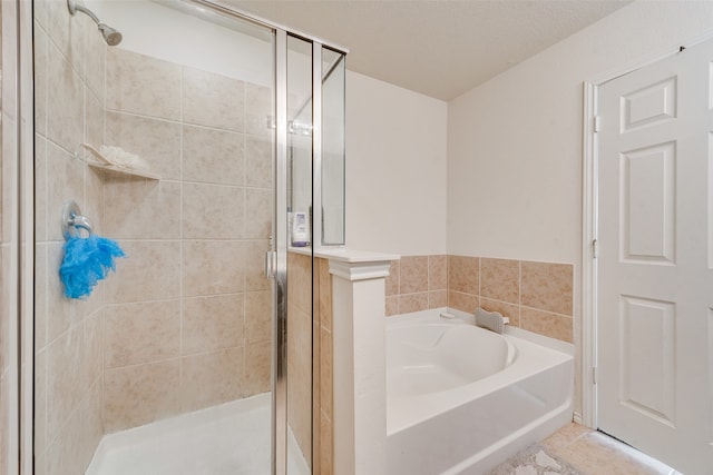 bathroom featuring a textured ceiling and independent shower and bath